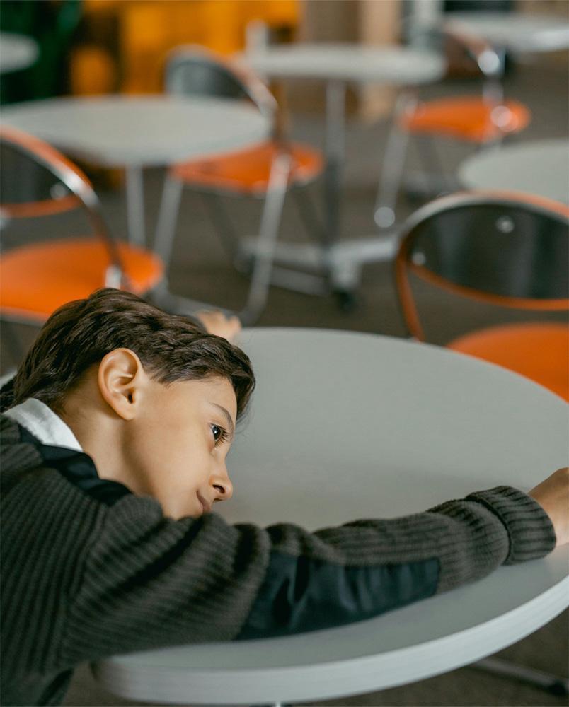 Junge mit Depressionen liegt auf einem Tisch